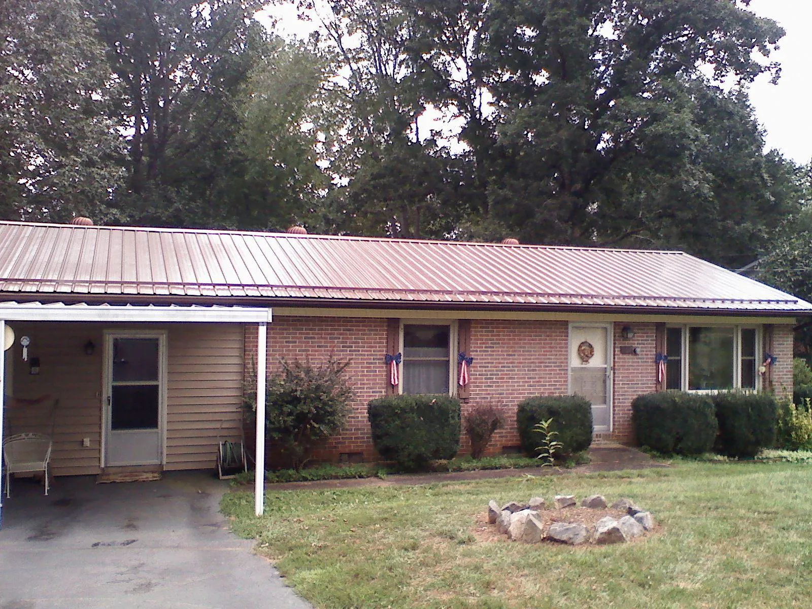 Bronze metal roof and carport on a brick ranch home — Roof Repair work by our crew in Havelock